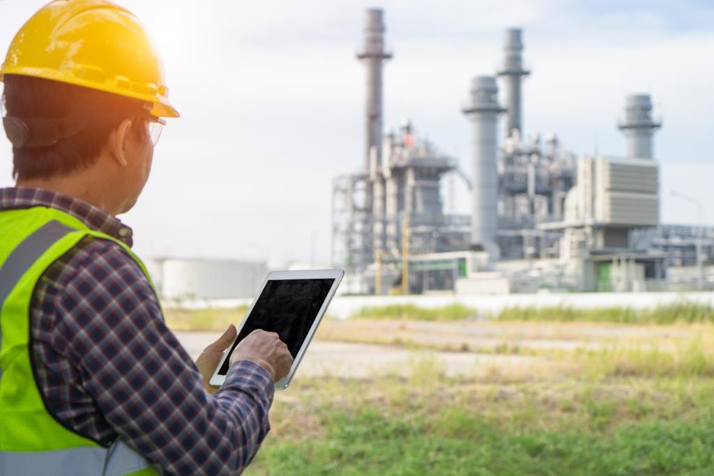 Energy assessment expert wearing a yellow helmet conducting safety study